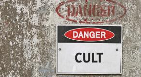 A sign on a wall warning 'Danger Cult'