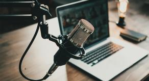 Podcast microphone next to a laptop