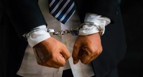 Close up of a man's wrists in handcuffs