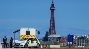 A police car parked by the beach in front of Blackpool Tower