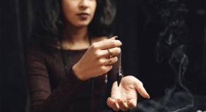 Modern fortune teller holding a dark jewel