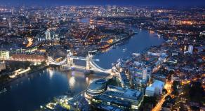 Ariel shot of the London skyline at night with Tower Bridge in the foreground