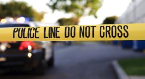 Crime scene tape and a parked police car
