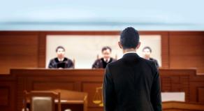 A defendant stands before a judge in a court room