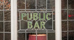 A photograph of a British pub's lead window, showing the words 'Public Bar'.