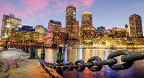 A stock photo showing the Boston Harbour and Financial District at night.