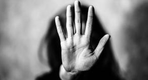 A woman with an outstretched palm in front of her facce