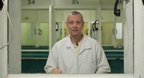 A prisoner sitting on the other side of the glass