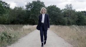 Emilia Fox walking along a dusty footpath in Peterborough
