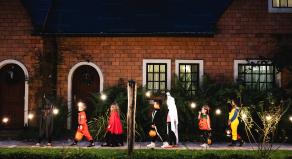A line of children dressed in costumes trick or treating