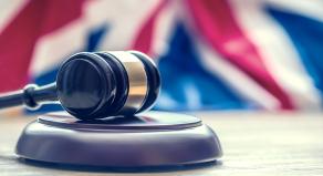 A photograph of a courtroom gavel and the Union Flag in the background