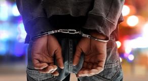 A photograph of a man in handcuffs