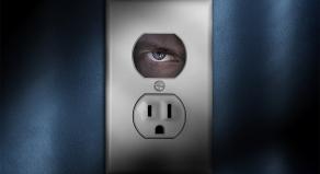 An eye looking through a plug socket