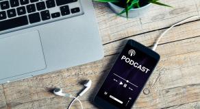 A phone playing a podcast on a desk