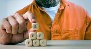 A graphic image of a prisoner building a pyramid out of dice