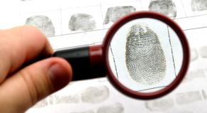 A small magnifying glass held over a fingerprint