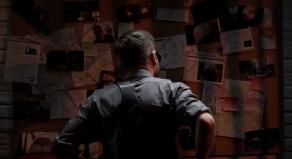 A detective looking at an evidence board