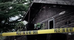 A stock image of a log cabin with police tape