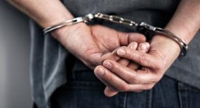 A man's hands handcuffed behind his back