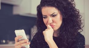 woman looks annoyed while reading a message