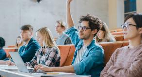 Student raises his hand while in a lecture