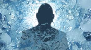 A silhouette of a person behind frozen ice