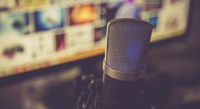 A podcast microphone in front of a laptop