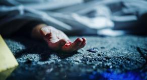 A bloodied hand of a body lying on the ground
