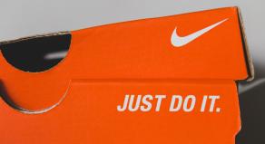 An orange Nike shoe box displaying the Nike tick and slogan, 'JUST DO IT.'