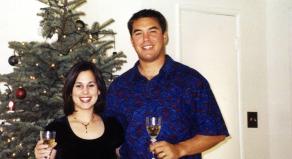Scott and Laci Peterson hold glasses of champagne in front of a Christmas tree