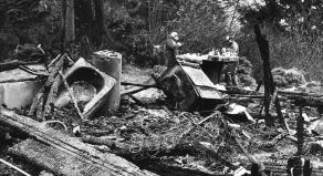 Two FBI agents sift through debris after a home burned to the ground