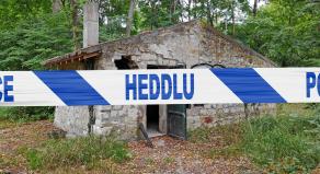 Police tape reading 'Heddlu' in front of an abandoned stone building