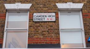 A street sign for 'Camden High Street' on the side of a building