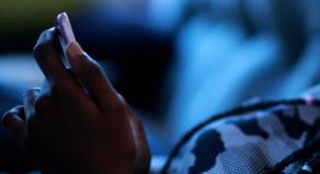 A black teenage girl hold a smartphone in her hands