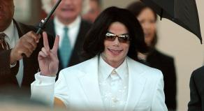 Michael Jackson flashes the 'Peace' sign to crowds of supporters as he arrives at court