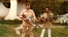 Klaus Barbie (L) holding a large gun during his time in South America