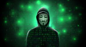 A hooded figure wearing an 'Anonymous' mask on a coded green background