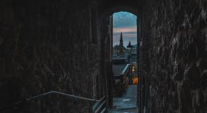 A twilight view of Edinburgh from a small, dark alley