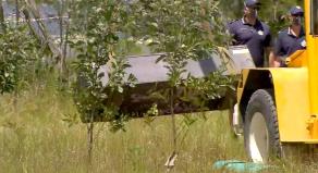 The toolbox containing two bodies is lifted out of the water by machinery