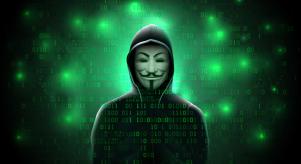 A hooded figure wearing an 'Anonymous' mask on a coded green background