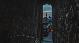 A twilight view of Edinburgh from a small, dark alley