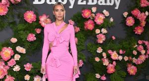 Kim Kardashian wearing a pink dress while posing for photos outside the Baby2Baby annual gala