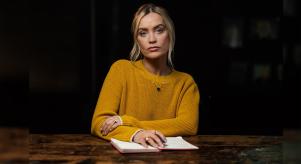 Laura Whitmore wearing a yellow jumper and sitting at a large table