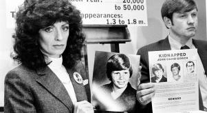 Noreen and John Gosch hold up photos of their missing son, Johnny