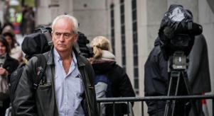 Nick Davies arrives at the Old Bailey court in London - surrounded by news cameras