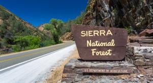 A sign by the side of the road marking the entrance to Sierra National Forest