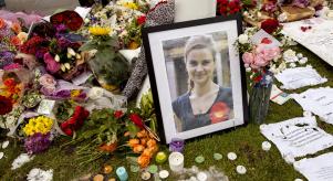 A photo of Jo Cox next to flowers, notes and candles at an impromptu memorial site