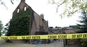 The burnt out Foster family mansion with yellow police tape in front of it