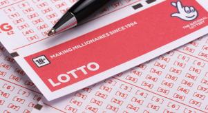 A blank Lotto ticket from the National Lottery with a black pen resting on top of it