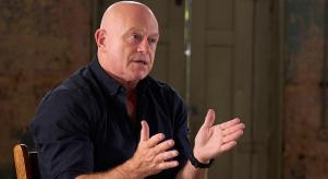 Ross Kemp gestures with his hands while talking to someone out of frame